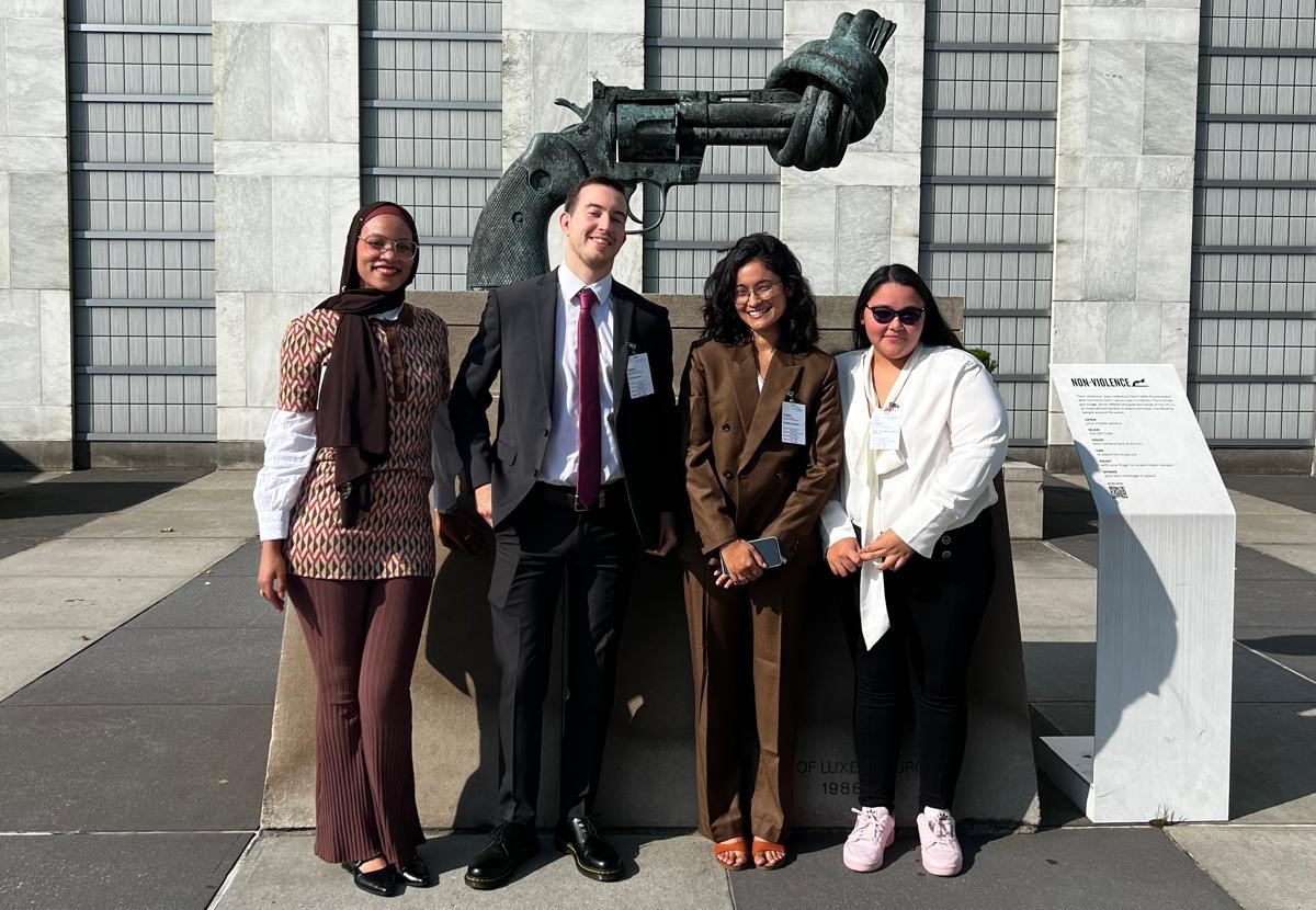 Youth Champions standing in front of the Knotted Gun statue