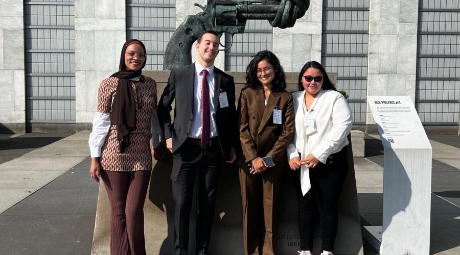 Youth Champions standing in front of the Knotted Gun statue