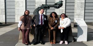 Youth Champions standing in front of the Knotted Gun statue